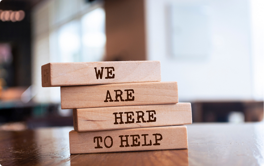 Color photo of blocks that read' We are here to help'.