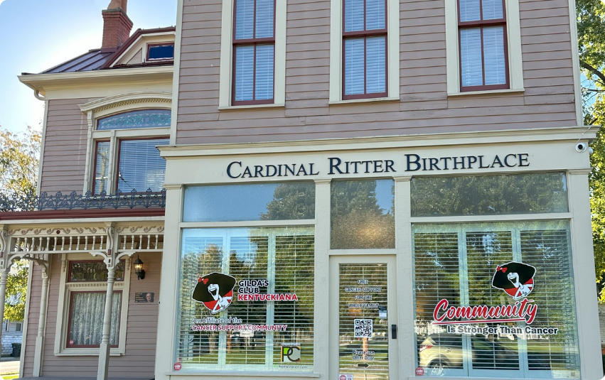 Color photo of the front of Cardinal Ritter Birthplace where Gilda's Club logo and Community is Stronger than Cancer is on the windows