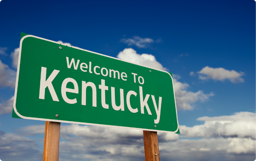 a green sign with white text saying Welcome to Kentucky