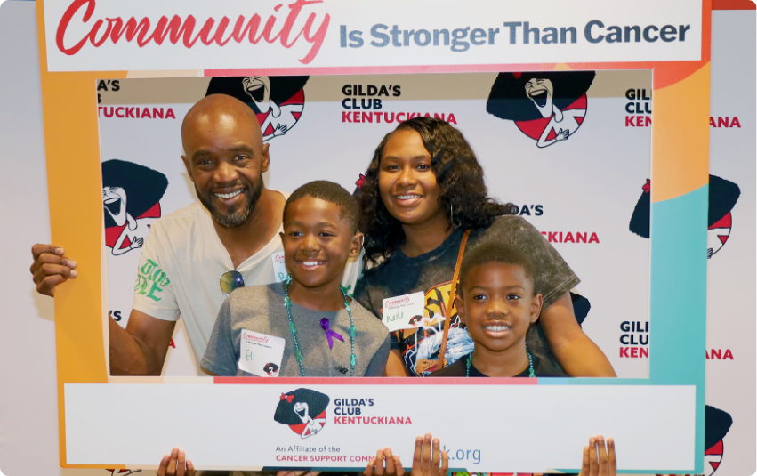 Photo of family holding up Community is Stronger than Cancer frame