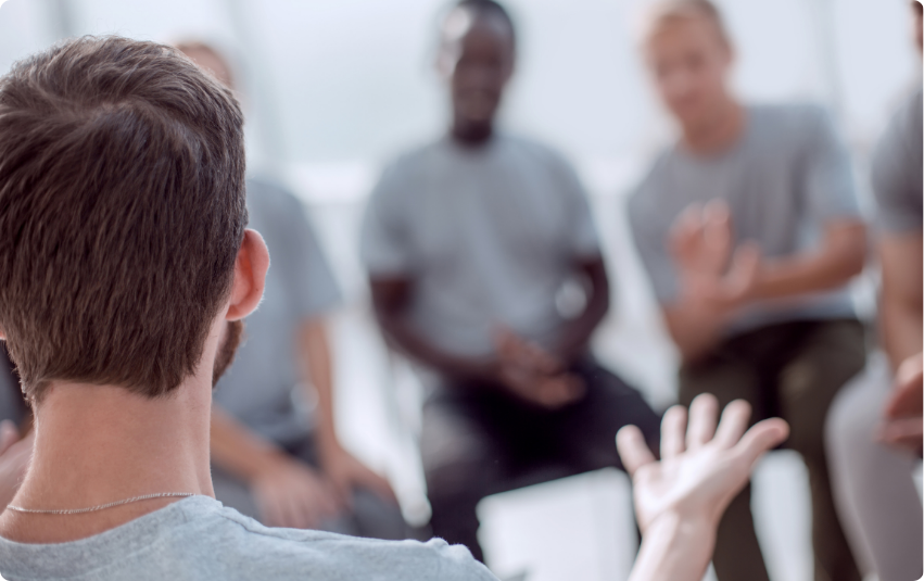 Blurred color photo of men in a support group.