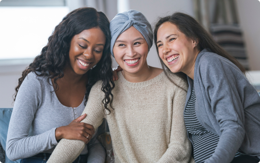 Three smiling women sitting closely together